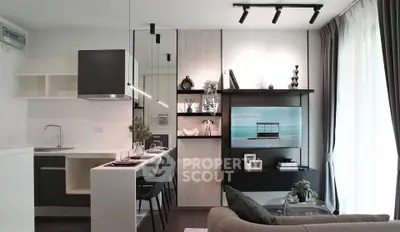 Modern living room with sleek kitchen and stylish decor, featuring open layout and natural light.