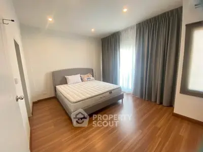 Spacious bedroom with elegant wooden flooring and natural light