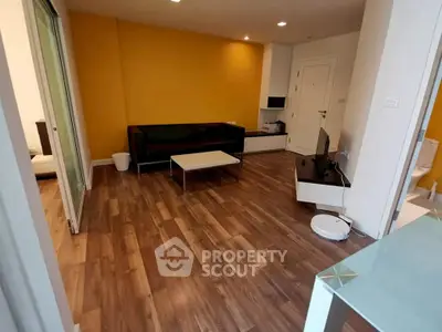 Modern living room with wooden flooring and vibrant yellow accent wall