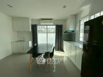 Modern kitchen with sleek black dining table and natural light