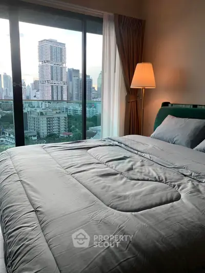 Luxurious bedroom with stunning city view from large window, elegant decor and cozy ambiance.