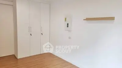 Minimalist room with wooden floor and built-in white wardrobe