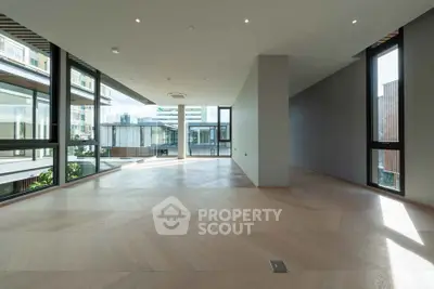 Spacious modern living room with large windows and wooden flooring