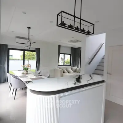 Modern open-plan living room with elegant dining area and stylish staircase