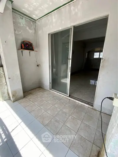 Spacious balcony with sliding glass doors and tiled flooring