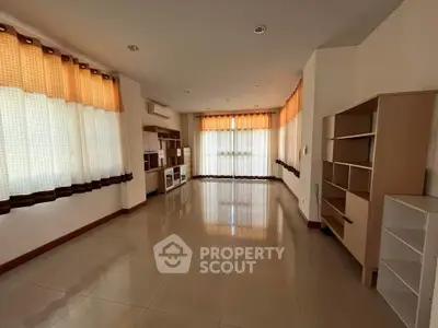 Spacious living room with large windows and built-in shelving