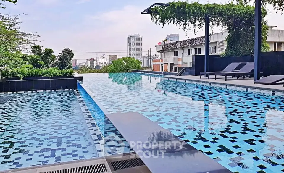 Luxurious rooftop infinity pool with city skyline view and modern lounge chairs.