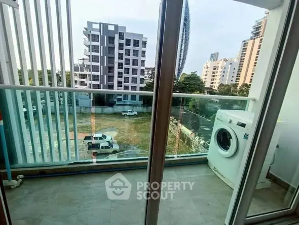 Modern balcony with washing machine and urban view, perfect for city living.
