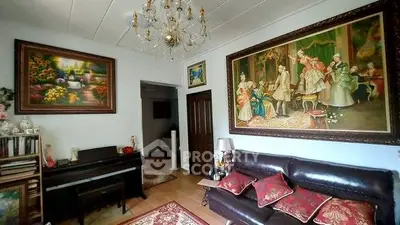 Elegant living room with classic paintings and chandelier, featuring a cozy leather sofa and piano.