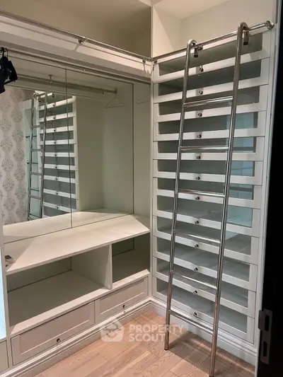 Luxurious walk-in closet with built-in shelves and ladder in modern home