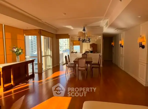Spacious living room with elegant dining area and large windows offering city views.