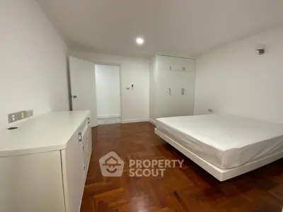 Spacious bedroom with wooden flooring and built-in wardrobe