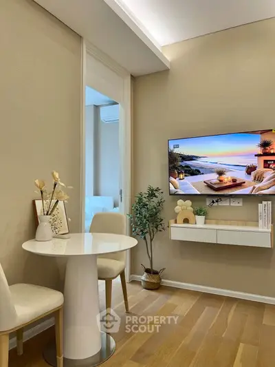 Modern living room with stylish decor and wall-mounted TV, featuring elegant furniture and warm lighting.