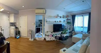 Spacious living room with modern decor and natural light, featuring a cozy seating area and entertainment setup.
