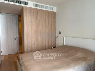 Cozy bedroom with wooden wardrobe and modern decor in a stylish apartment.