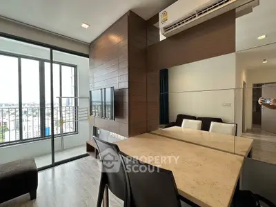 Modern living room with balcony and city view, featuring sleek furniture and air conditioning.