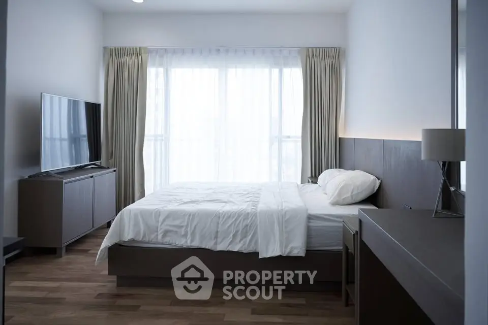 Modern bedroom with large window and stylish furnishings, perfect for a serene living experience.