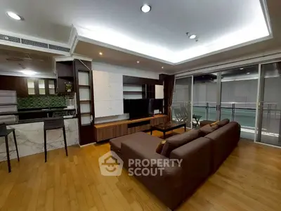 Spacious modern living room with open kitchen and large balcony access