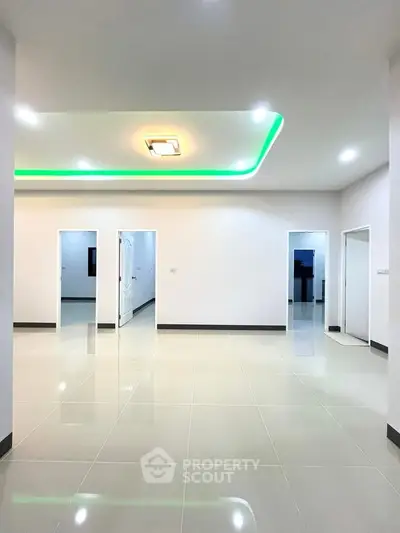 Spacious modern interior with sleek lighting and tiled flooring, ideal for versatile living spaces.