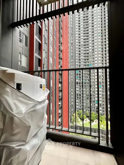 Modern high-rise balcony with cityscape view and washing machine setup.