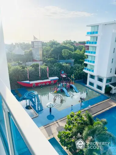 Inviting family-friendly condominium complex with a vibrant children's pool area, complete with slides and play structures, surrounded by lush greenery and modern buildings.