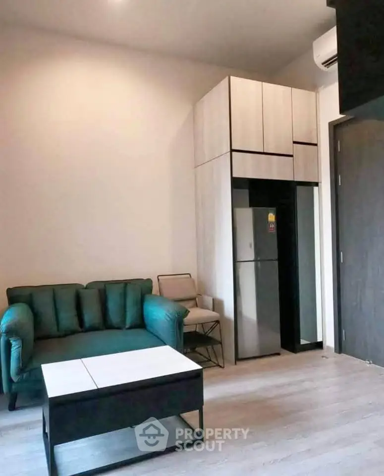 Modern living room with stylish furniture and compact kitchen area, perfect for urban living.