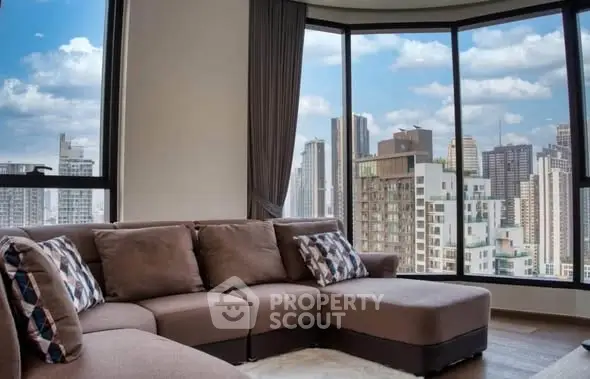 Luxurious living room with panoramic city views and modern furnishings.