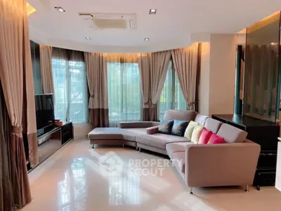 Luxurious living room with modern decor and large windows offering natural light.