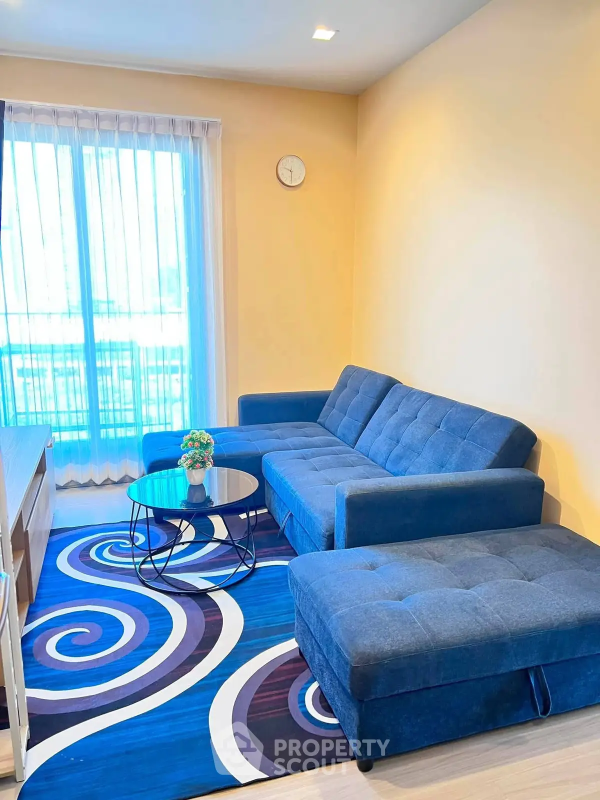 Stylish living room with blue sectional sofa and modern decor in bright apartment.