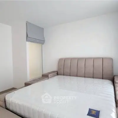 Spacious bedroom with modern bed and natural light, perfect for relaxation.