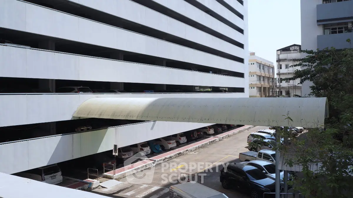 Multi-level parking structure with covered walkway in urban setting