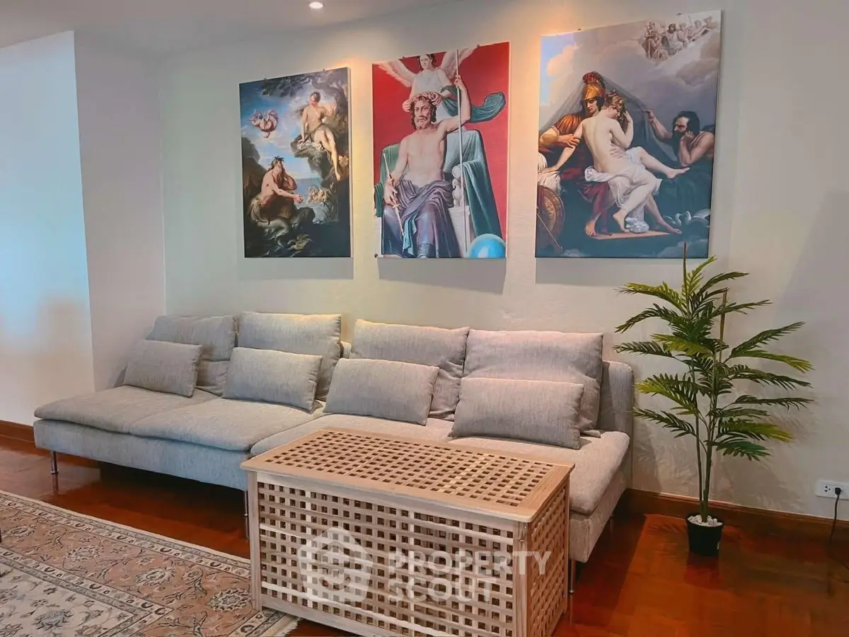 Stylish living room with modern sofa, artistic wall decor, and elegant wooden flooring.