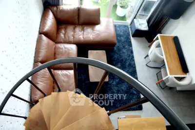 Modern living room with spiral staircase and leather sectional sofa