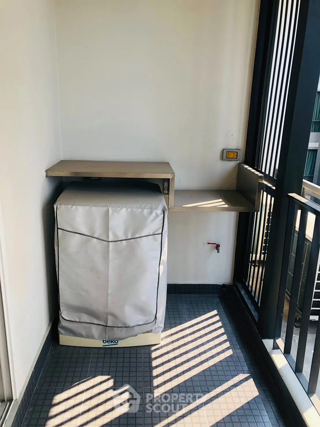 Compact balcony with washing machine and shelves, ideal for urban living.