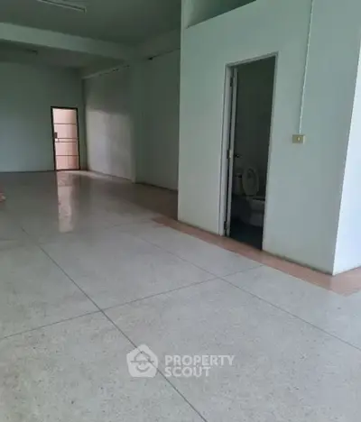 Spacious interior with tiled flooring and attached bathroom, ideal for customization.