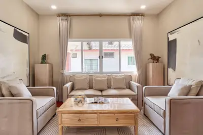 Elegant living room with neutral tones, plush sofas, and large window offering natural light.