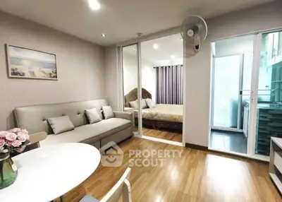 Modern living room with wooden flooring and cozy bedroom view