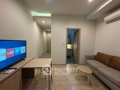 Modern living room with TV, sofa, and dining table in a cozy apartment setting.