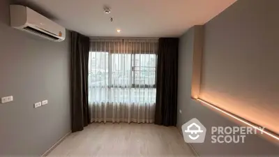 Modern empty room with large window and city view, featuring sleek air conditioning unit and elegant lighting.