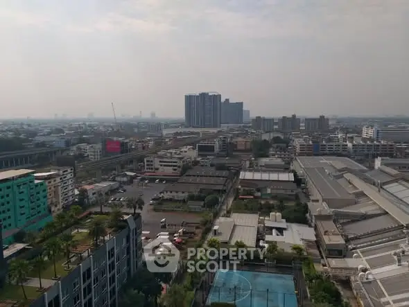 Panoramic cityscape view with residential and commercial buildings under a cloudy sky.