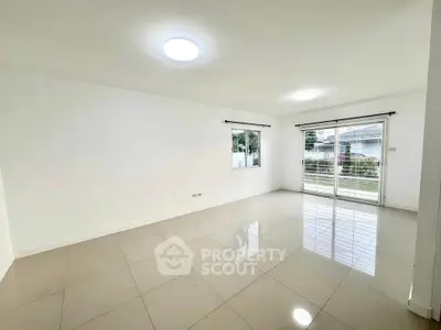Spacious empty living room with glossy tiled floors and large windows for natural light.