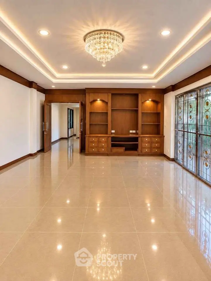 Luxurious living room with elegant chandelier and built-in wooden shelves