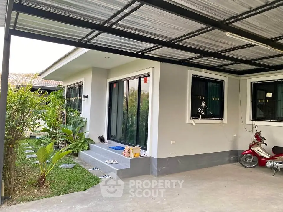 Charming single-story home with covered carport and lush garden area.