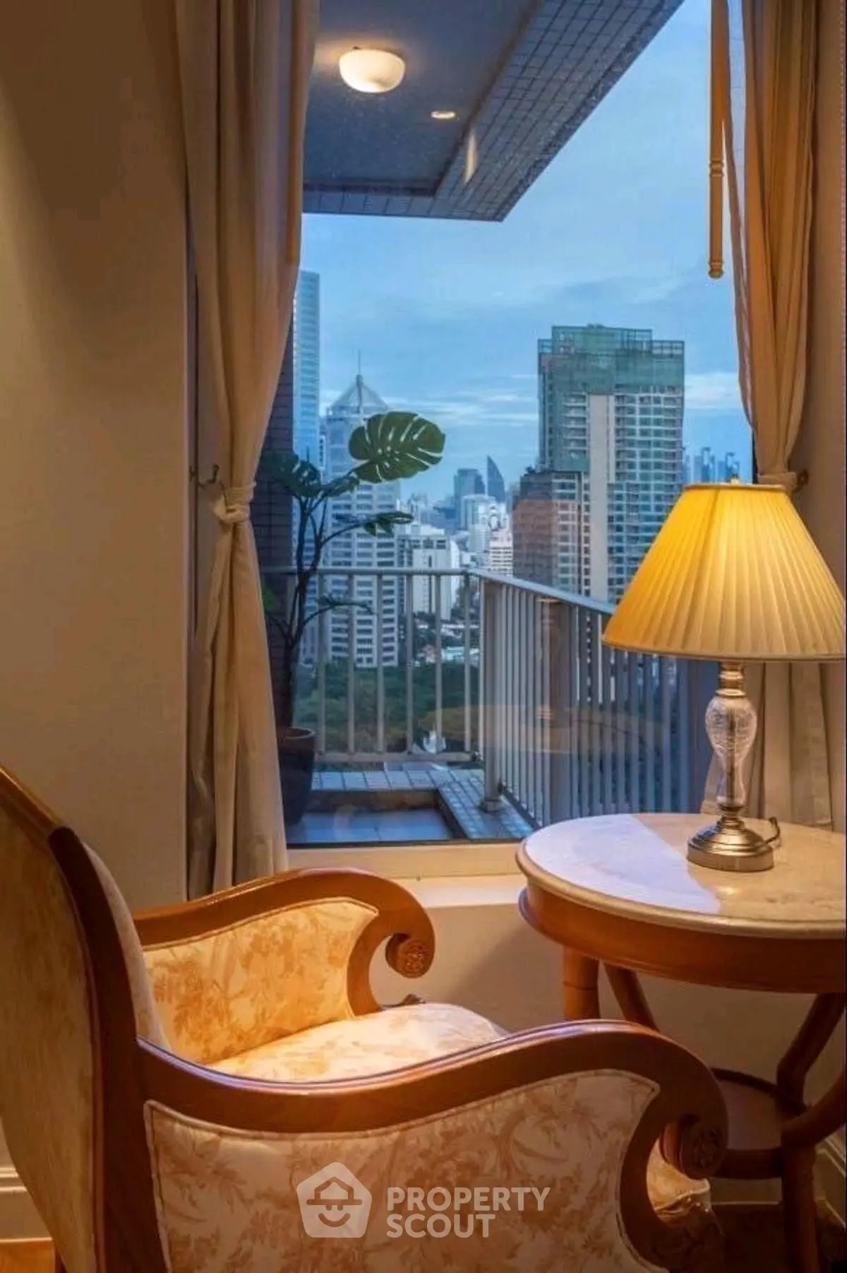 Cozy living room with elegant chair and city view from balcony