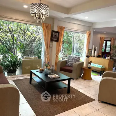 Spacious living room with large windows and garden view, featuring modern furniture and elegant decor.