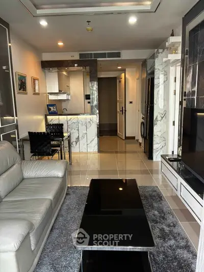 Modern living room with marble accents and open kitchen layout in a stylish apartment.