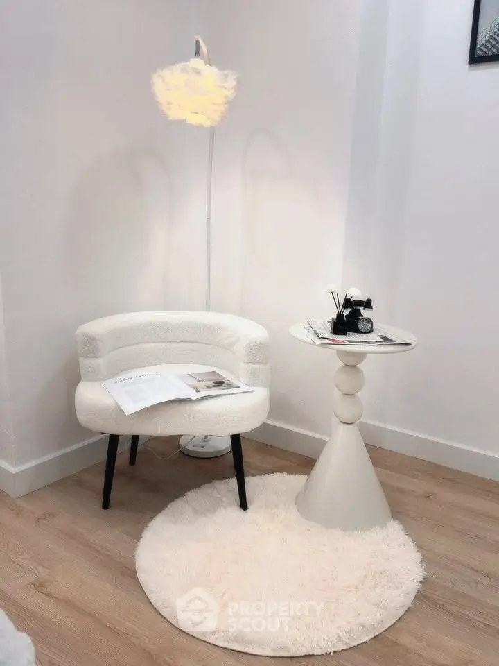 Chic modern corner with plush chair, stylish side table, and soft rug in a cozy interior setting.