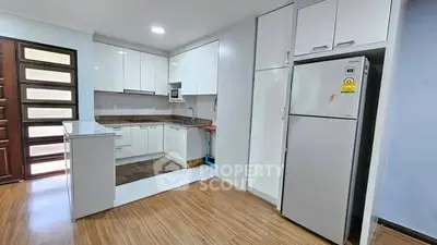 Modern kitchen with sleek white cabinets and stainless steel fridge