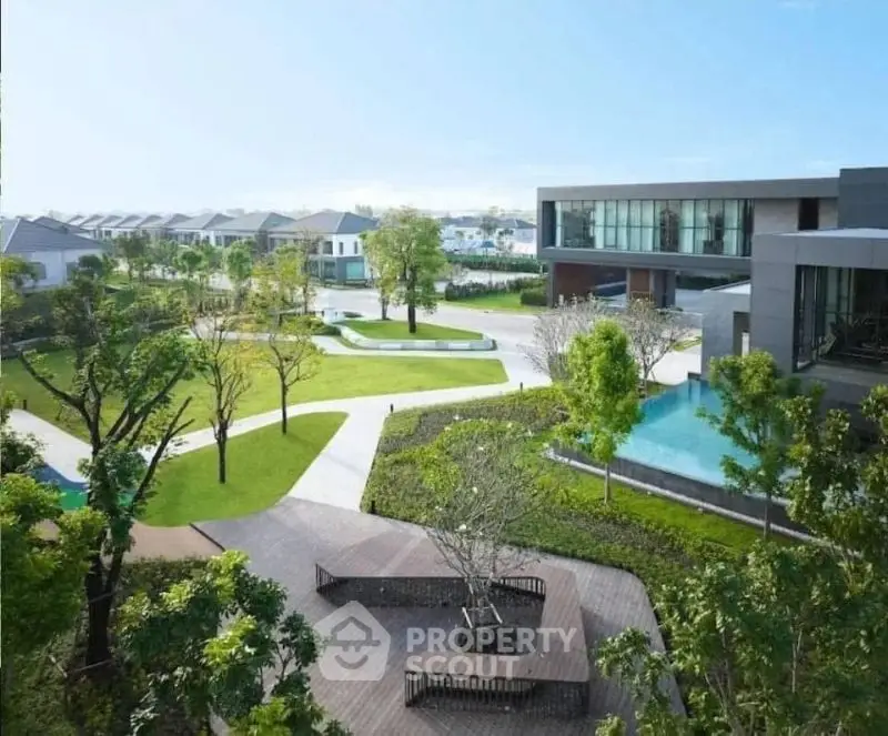 Luxurious modern residential complex with lush green gardens and serene water features.