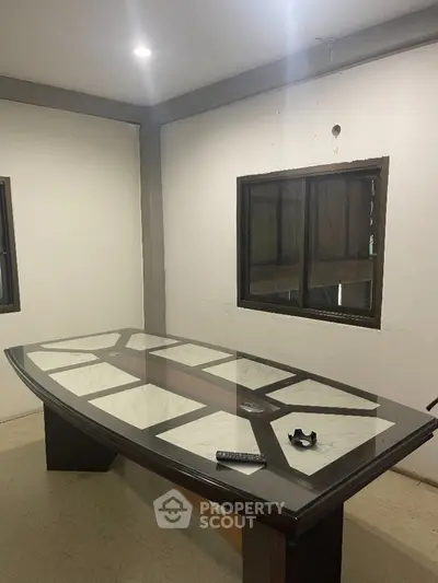Modern study room with elegant glass-top table and remote control, ideal for productivity.